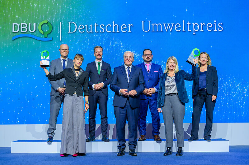 Verleihung des Deutschen Umweltpreises 2023 (von links): Schleswig-Holsteins Umweltminister Tobias Goldschmidt, Klimaforscherin Prof. Dr. Friederike Otto, DBU-Kuratoriumsvorsitzender Prof. Dr. Kai Niebert, Bundespräsident Frank-Walter Steinmeier, DBU-Generalsekretär Alexander Bonde, Holzbau-Unternehmerin Dagmar Fritz-Kramer und Bundesumweltministerin Steffi Lemke